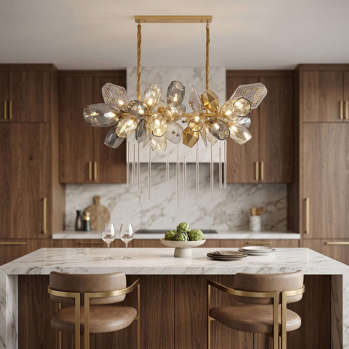 Britannica glass chandelier providing statement kitchen island lighting above a white marble counter.