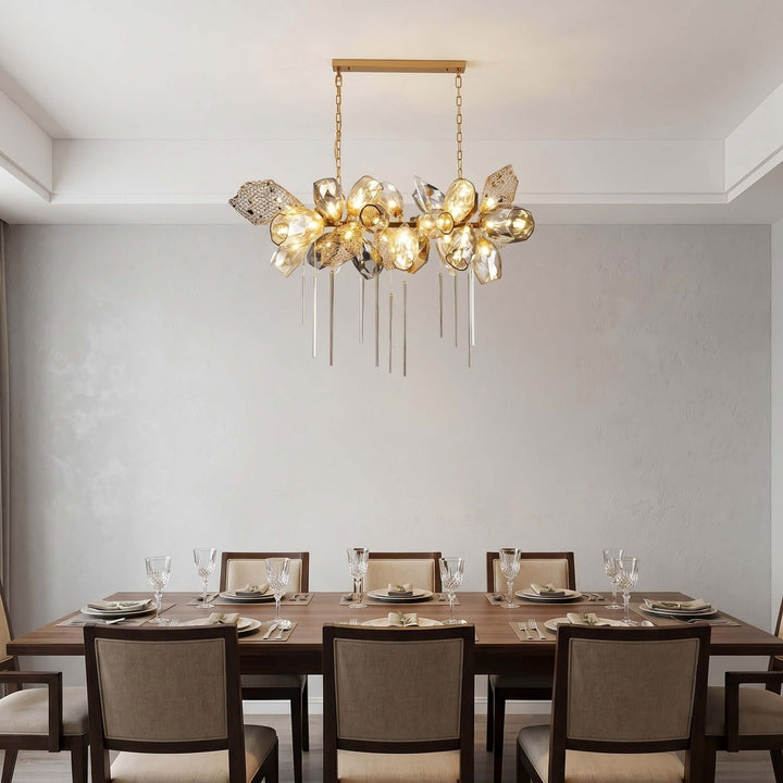 Linear Britannica dining room chandelier with illuminated faceted glass shades above a wood table.