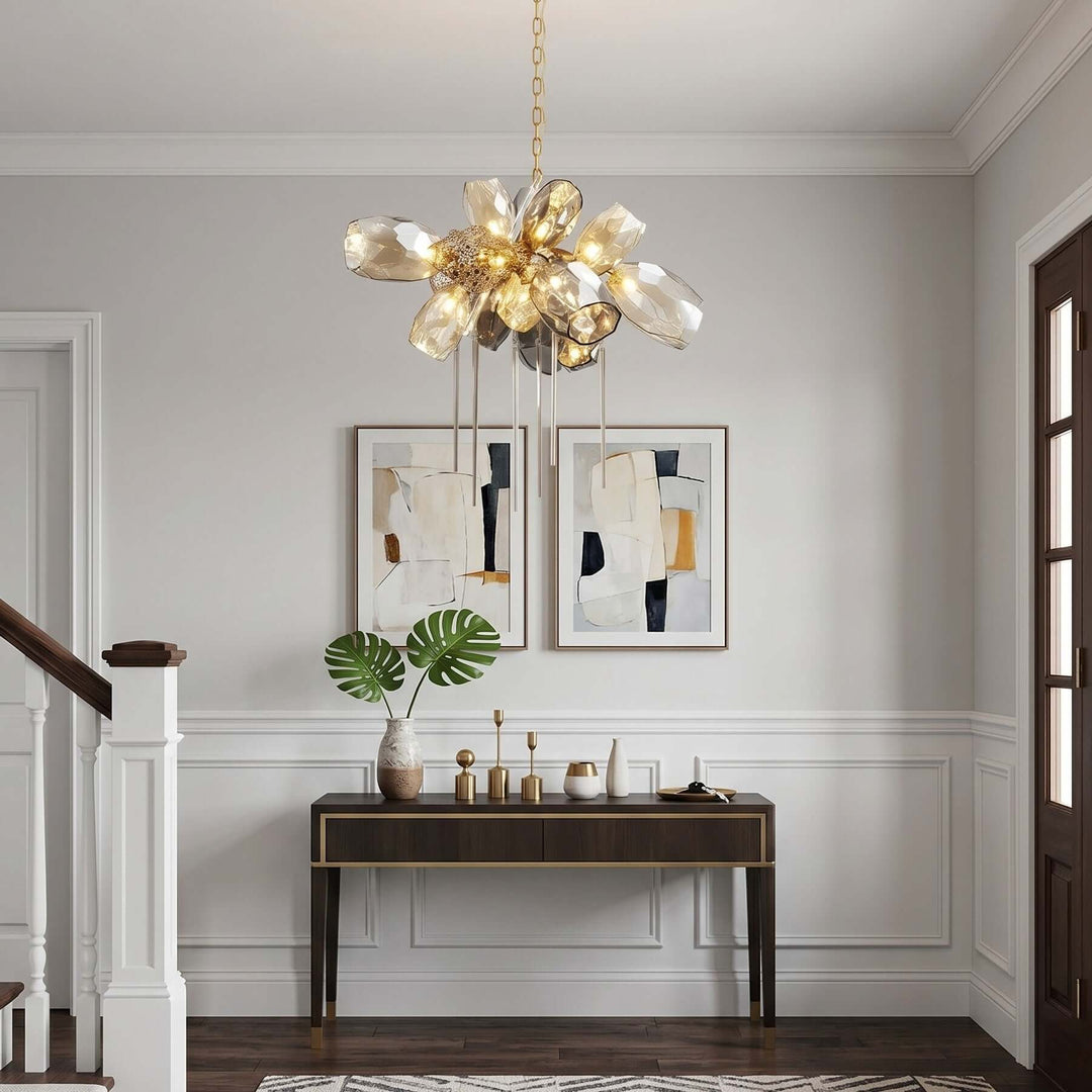 Round Britannica chandelier illuminating a bright entryway with a wood console and framed artwork.