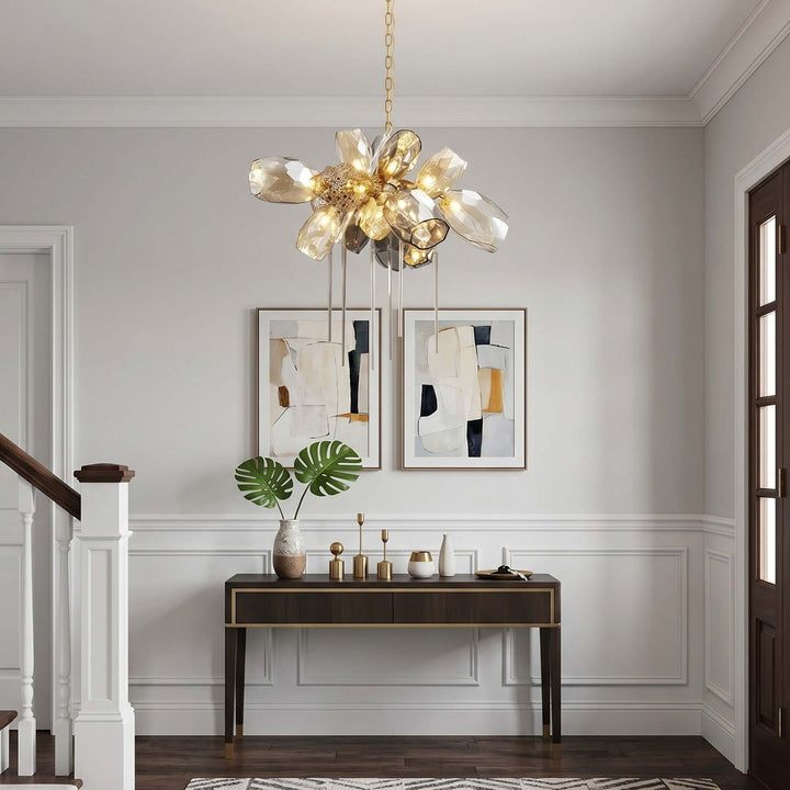 Round Britannica chandelier illuminating a bright entryway with a wood console and framed artwork.