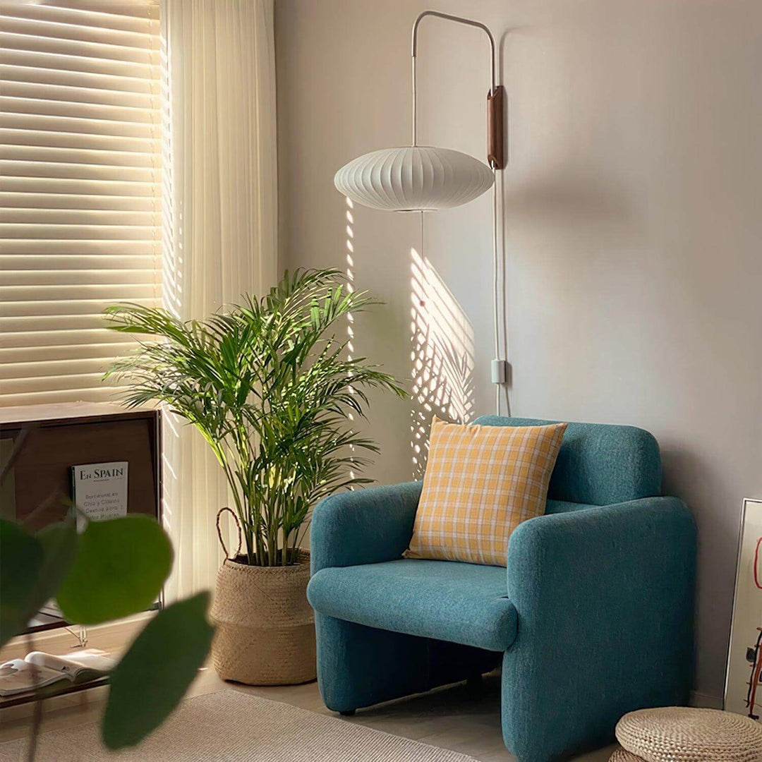 Wide Bubble Ball wall sconce above a blue accent chair in a sunlit reading nook
