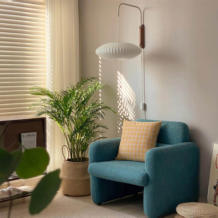 Wide Bubble Ball wall sconce above a blue accent chair in a sunlit reading nook