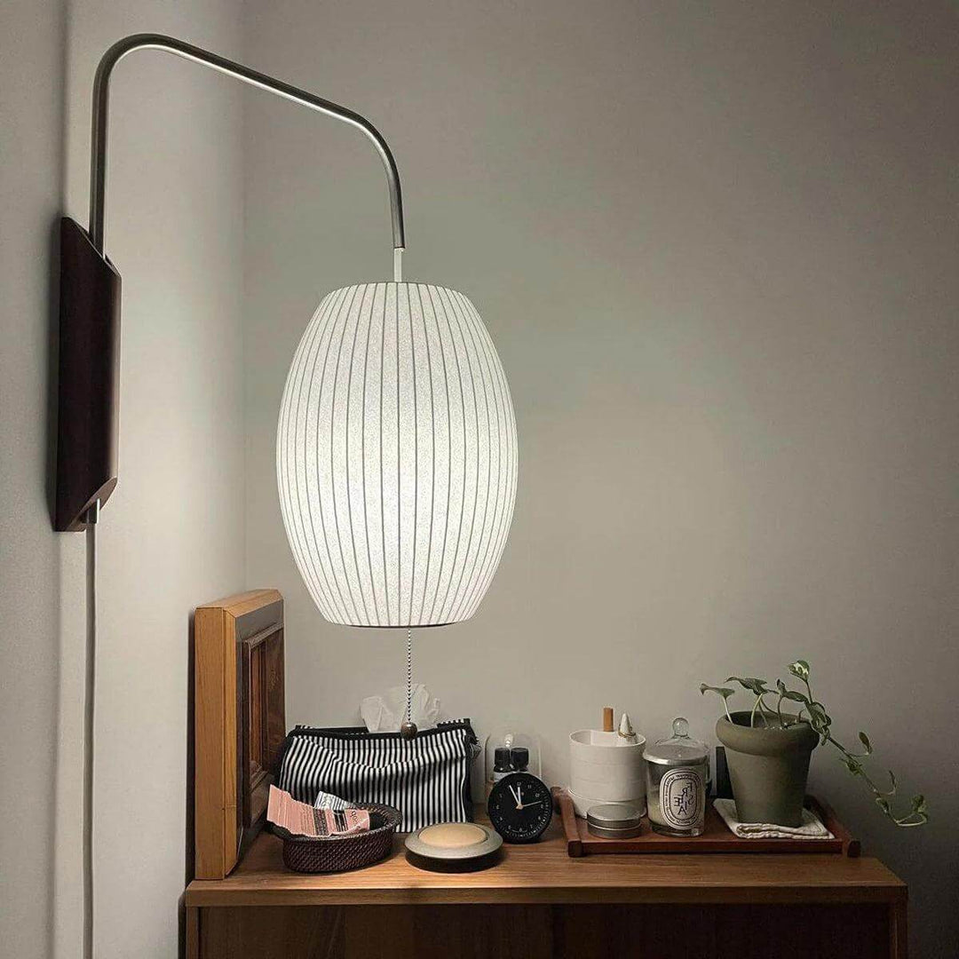 Illuminated oval Bubble Ball wall sconce mounted above a wood dresser with decorative objects