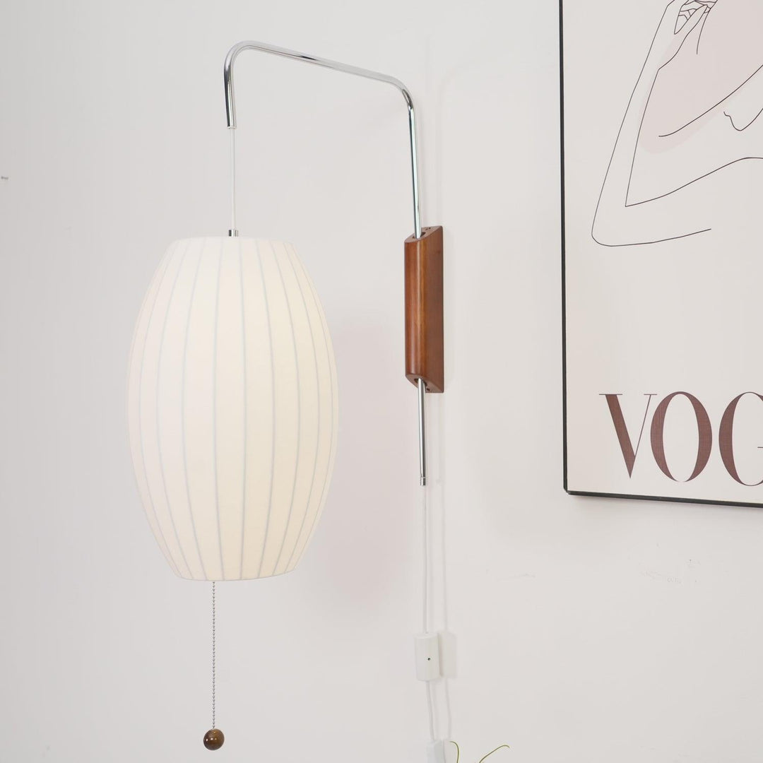 Glowing oval Bubble Ball wall sconce beside minimalist framed artwork on a white wall