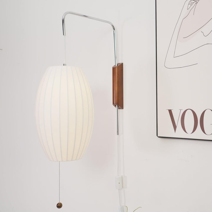 Glowing oval Bubble Ball wall sconce beside minimalist framed artwork on a white wall