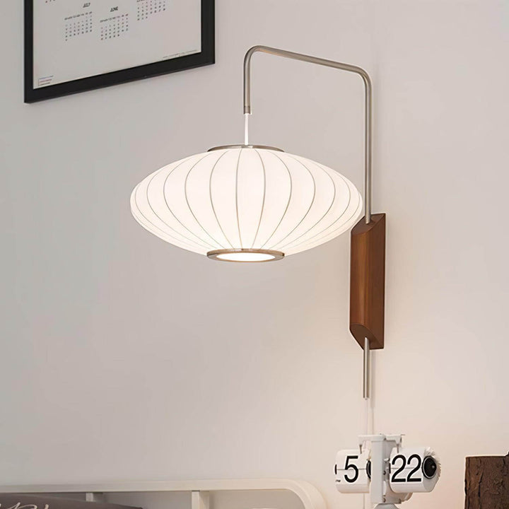 Glowing wide Bubble Ball wall sconce above a desktop clock in a minimalist workspace
