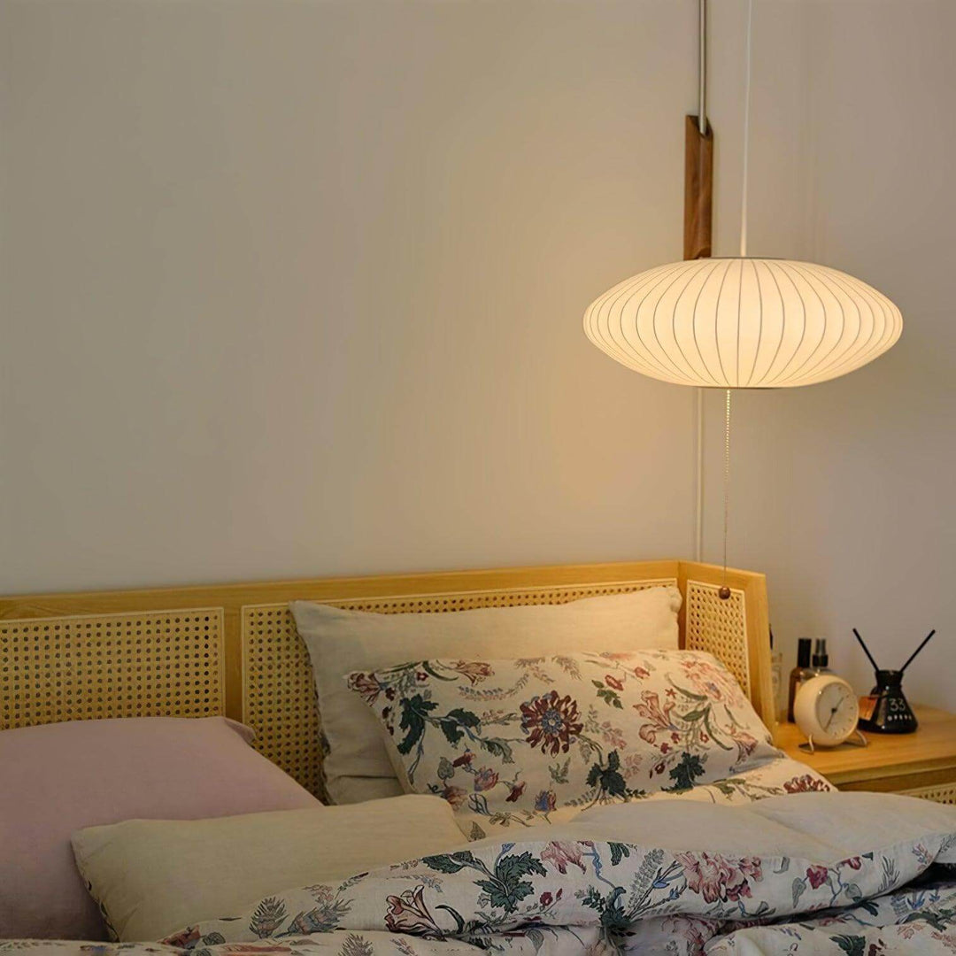 Wide-shade Bubble Ball wall sconce above a bed with floral bedding