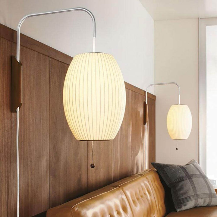Pair of oval Bubble Ball wall sconces illuminating a leather sofa and wood-paneled wall