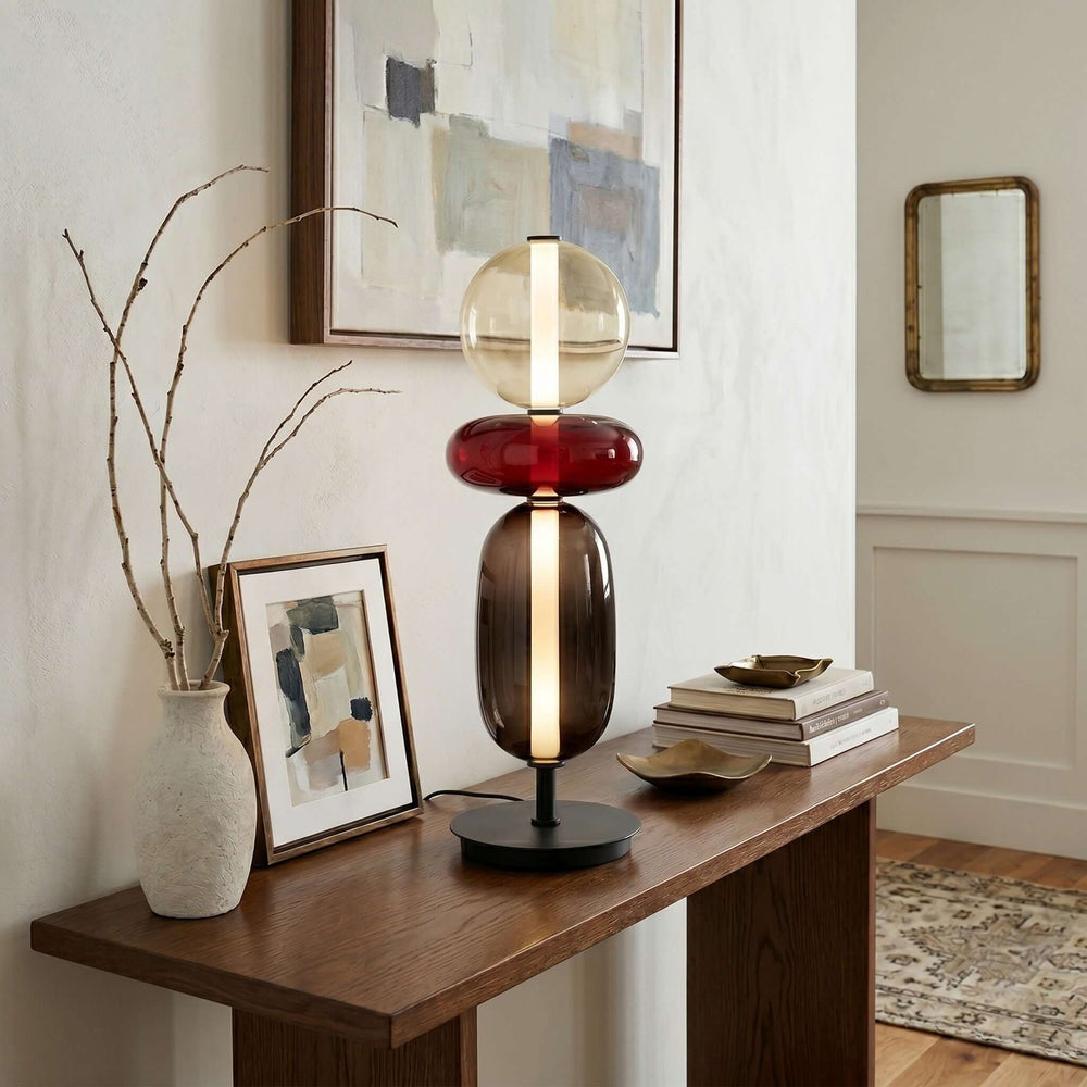 Colorful art deco glass table lamp with red and smoked stacked forms on a wood entryway console