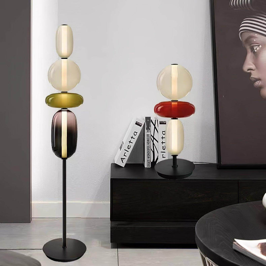Candied green glass floor lamp and red table lamp displayed together in a black-and-white interior.