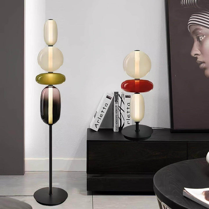 Candied green glass floor lamp and red table lamp displayed together in a black-and-white interior.