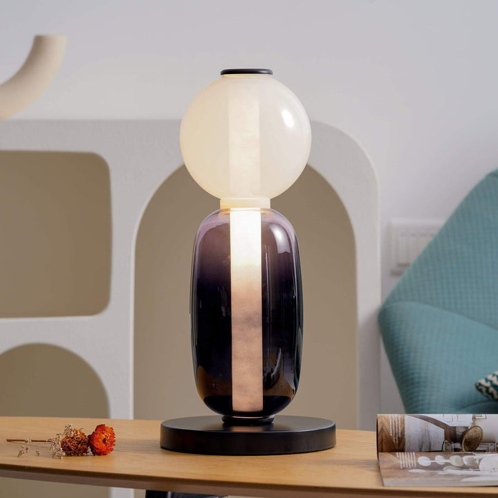 Front view of an art deco glass table lamp with frosted globe, smoked body and round black base