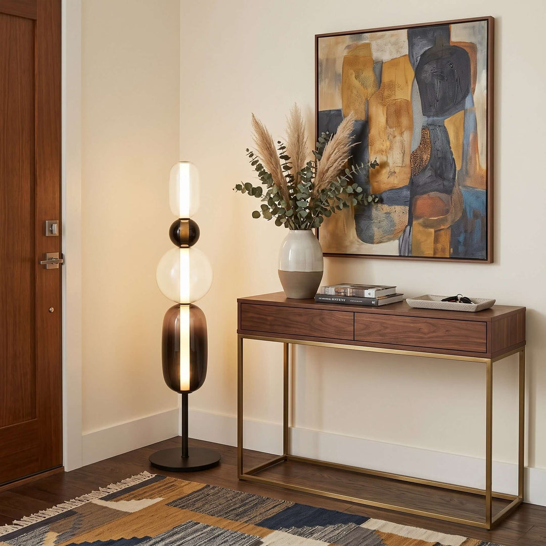 Candied Model B Black floor lamp beside a walnut console and colorful abstract art in an entryway.