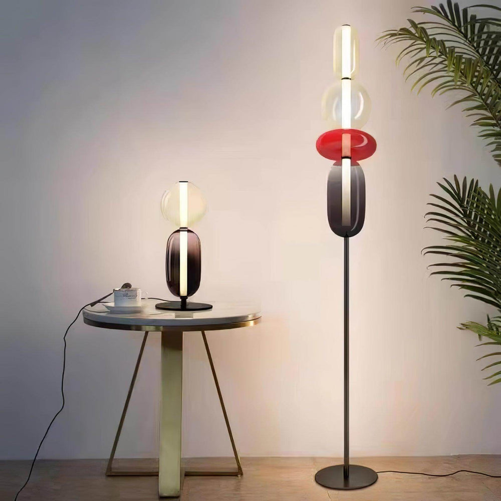 Red Candied Glass Floor Lamp and matching table lamp glowing beside a round table and palm plant.