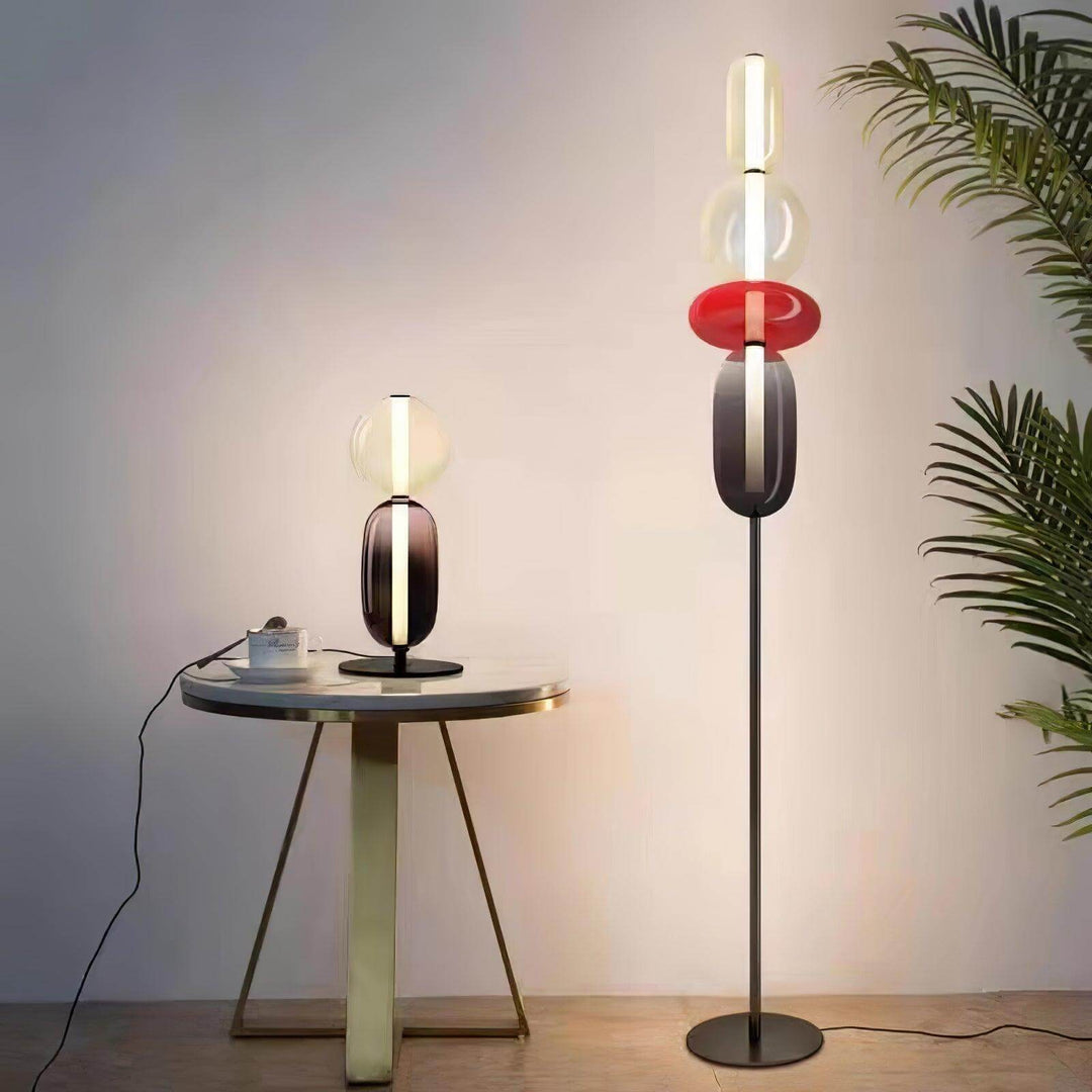 Red Candied Glass Floor Lamp and matching table lamp glowing beside a round table and palm plant.