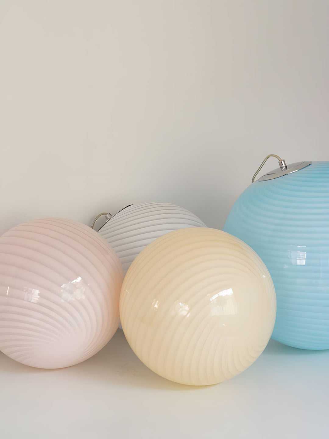 Candy Glass Pendant Light shades in pink, white, yellow, and light blue color options.