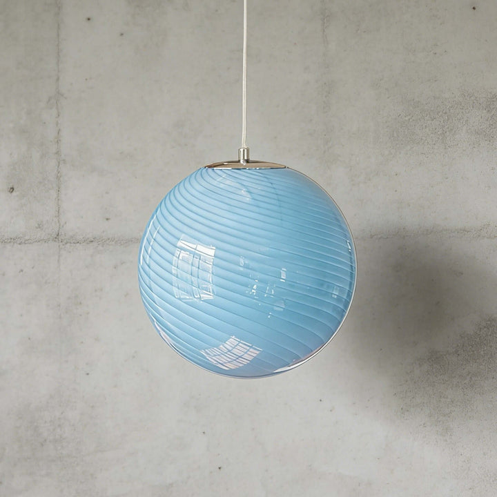Light blue Candy ribbed glass pendant light shown against a textured gray wall.