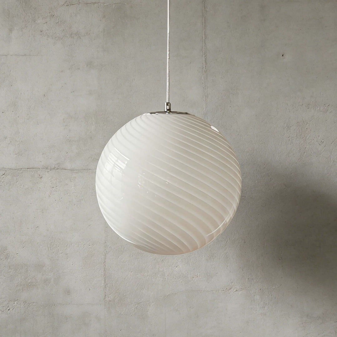 White Candy ribbed glass pendant light shown against a textured gray wall.