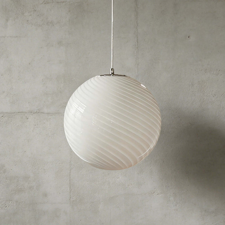 White Candy ribbed glass pendant light shown against a textured gray wall.