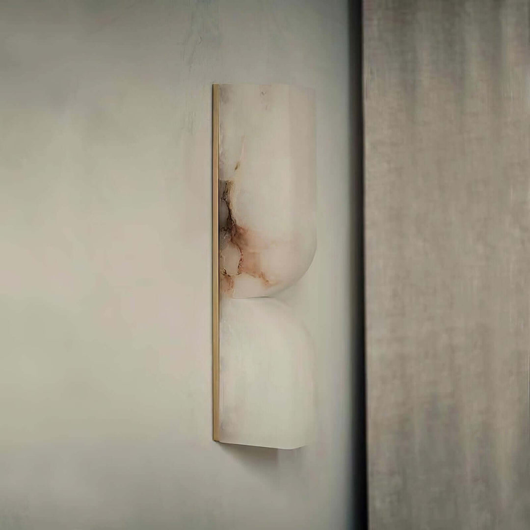 Unlit Cavira Wall Sconce shown from the side with pale alabaster, dark natural veining and a slim metal frame