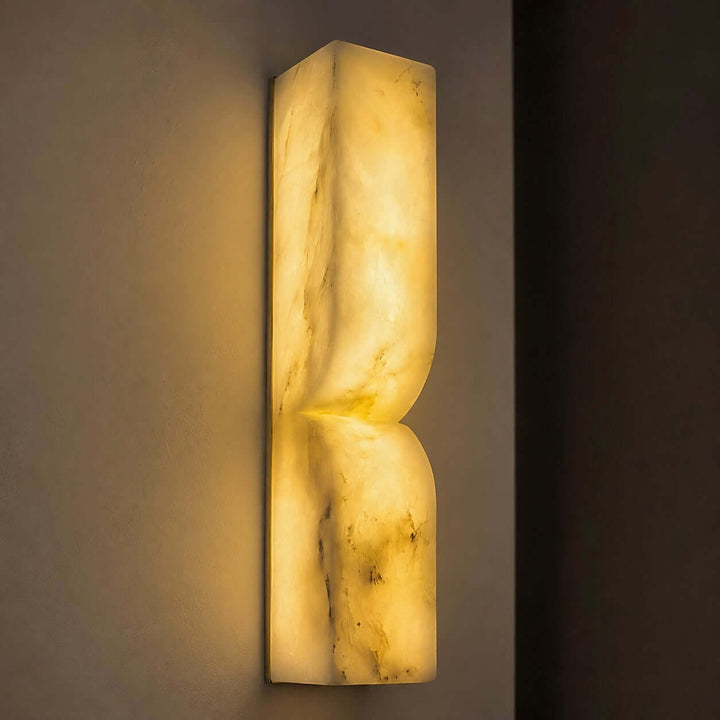 Close view of the illuminated Cavira Wall Sconce showing warm light through natural Spanish alabaster veining