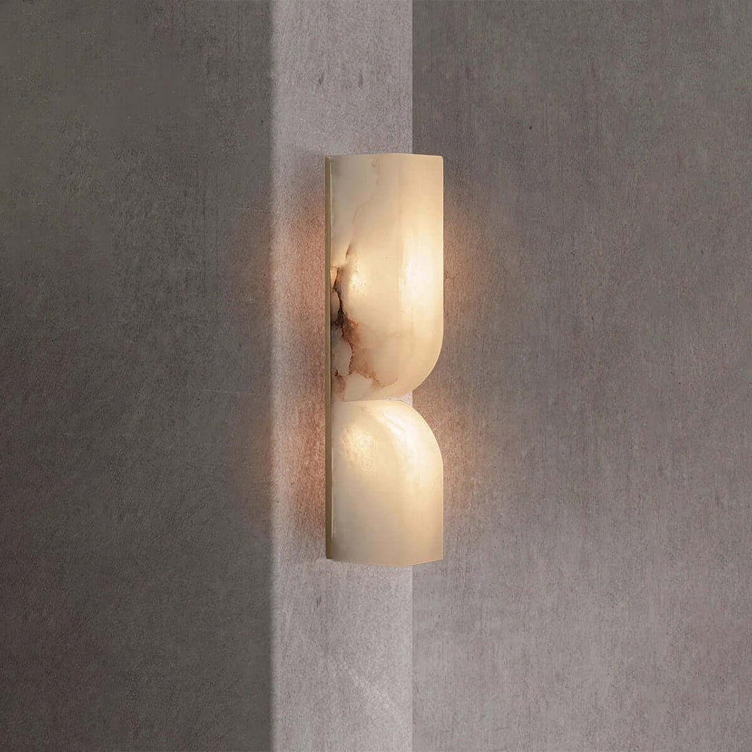 Illuminated Cavira Wall Sconce showing reddish natural veining across the Spanish alabaster surface