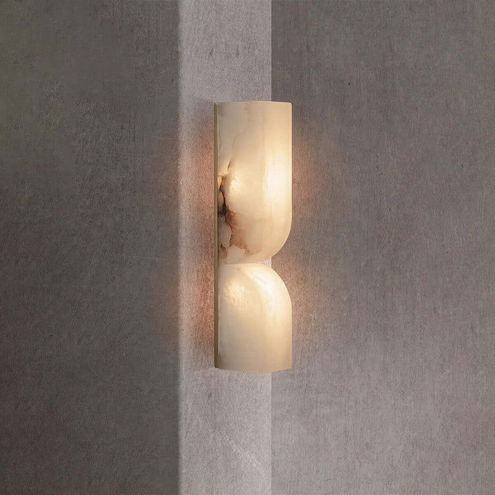 Illuminated Cavira Wall Sconce showing reddish natural veining across the Spanish alabaster surface