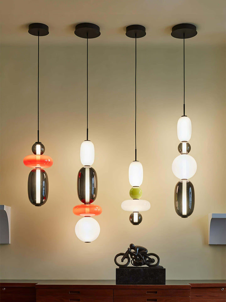 Four colorful glass hanging lights displayed at different suspension heights