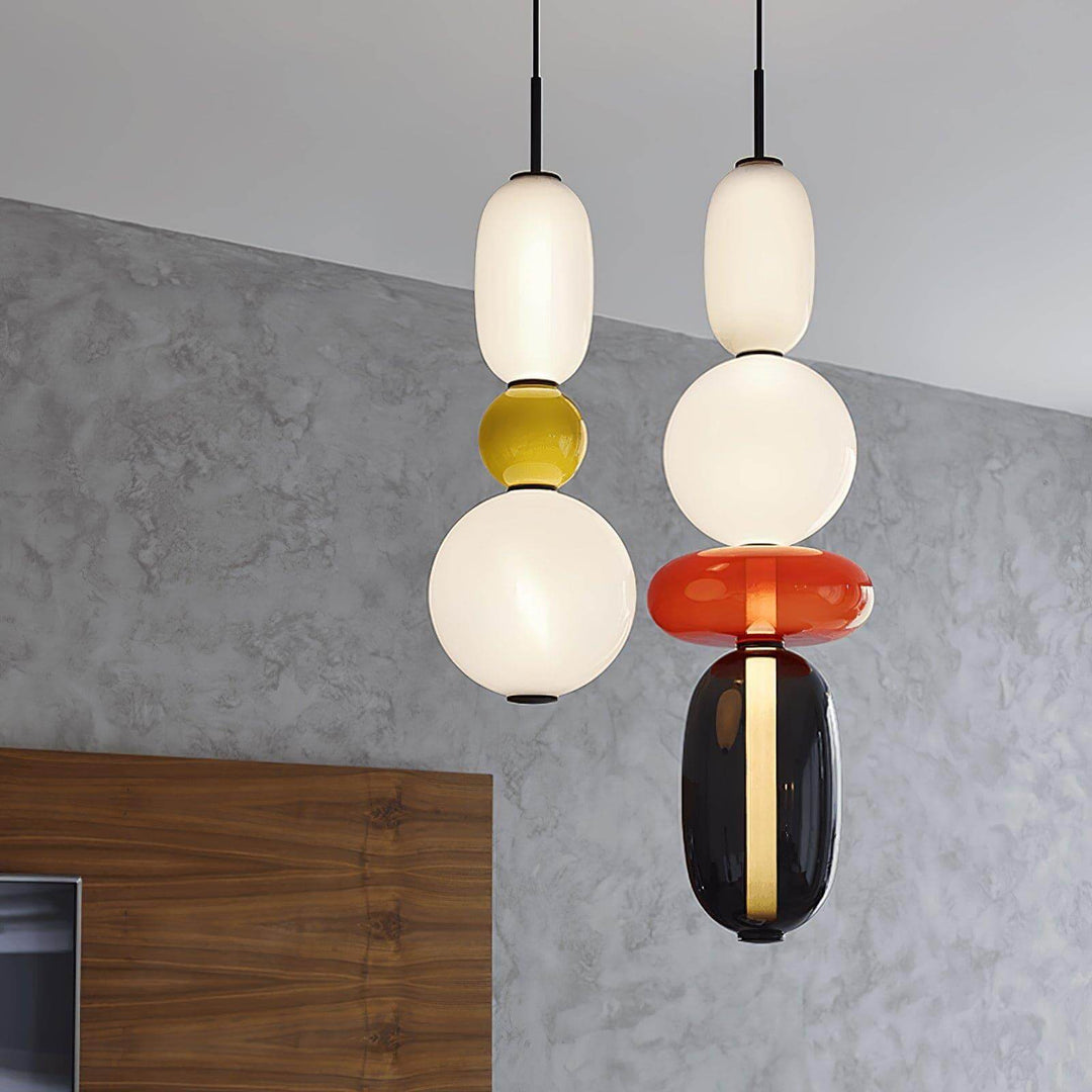 Two illuminated LED glass pendant lights in red, green, smoked and cream glass