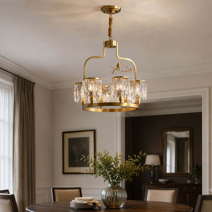 Close view of the Crystal Bird dining room chandelier above a round table with glowing crystal shades