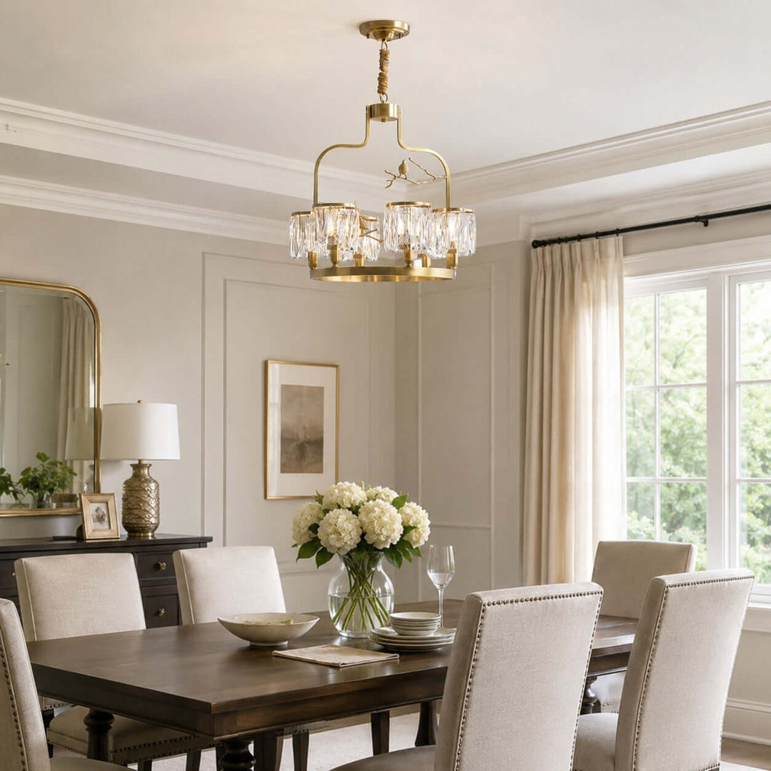 Crystal Bird dining room chandelier in brass and clear crystal above a dark wood table
