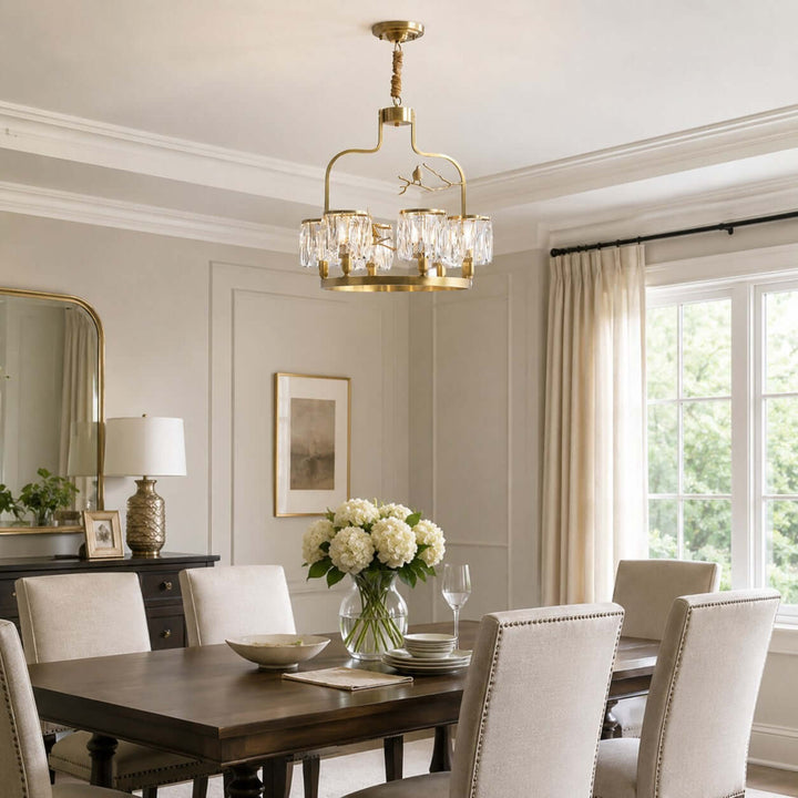 Crystal Bird dining room chandelier in brass and clear crystal above a dark wood table
