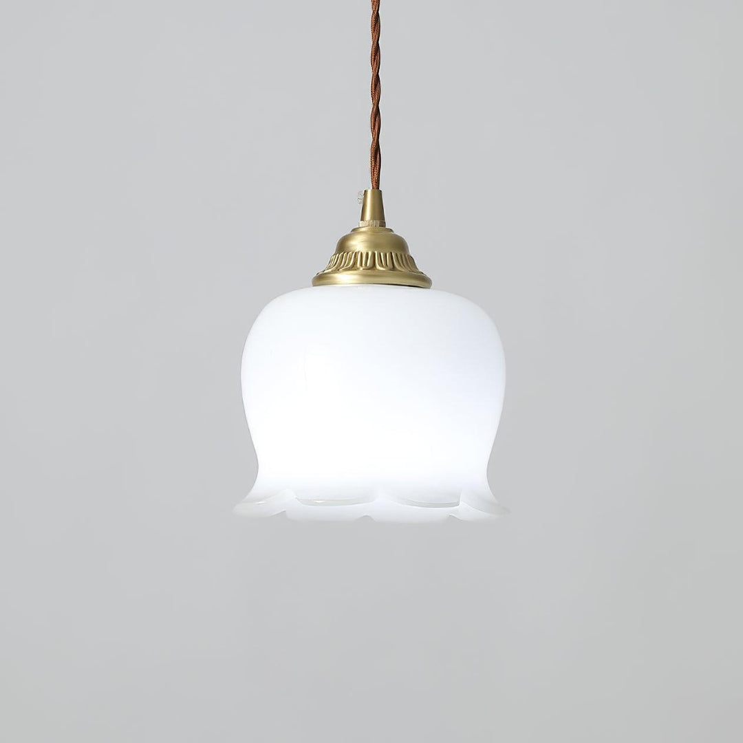 Flower pendant light illuminated with cool white light, showing the smooth resin shade and brass hardware
