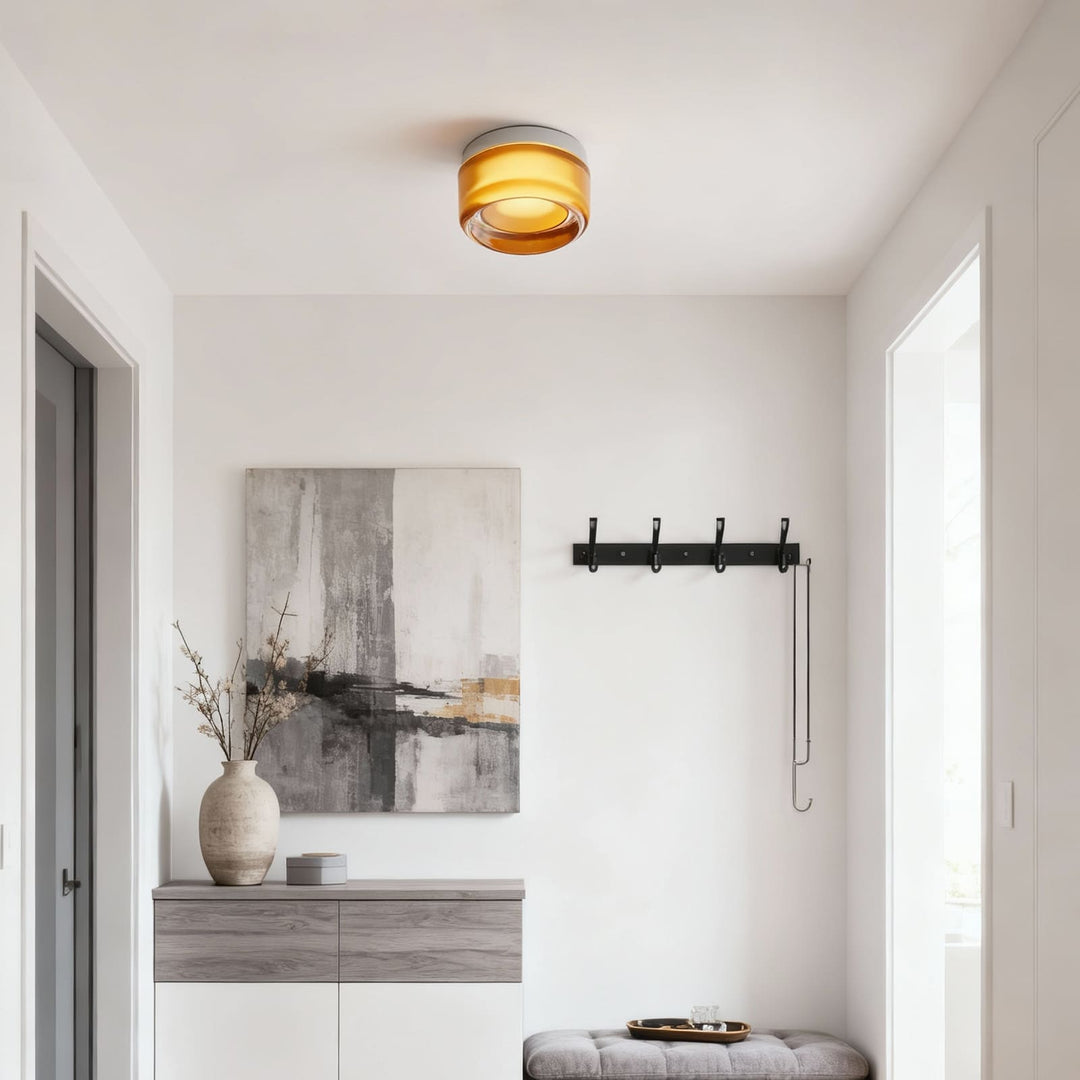 Amber glass fixture mounted on an entryway ceiling above a console and bench.