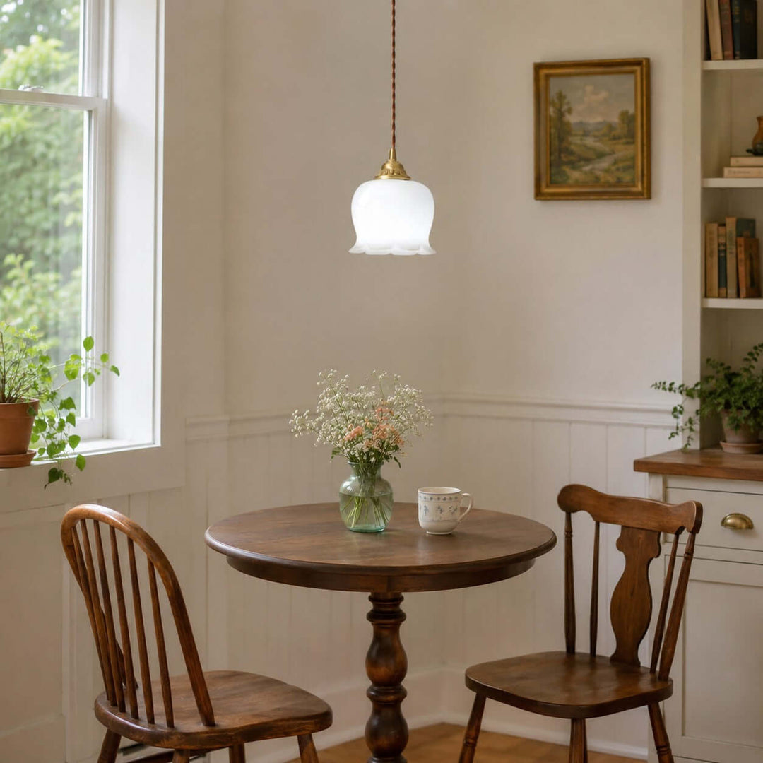 Valley flower pendant light above a round wooden dining table in a bright cottage-style room
