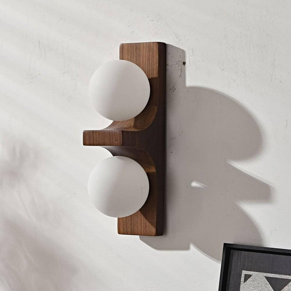 Dark wood double wall sconce with two white glass globes mounted on a textured wall with shadow