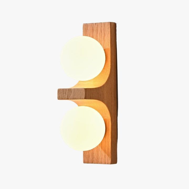 Light wood double wall sconce with two glowing white globes on a clean white background