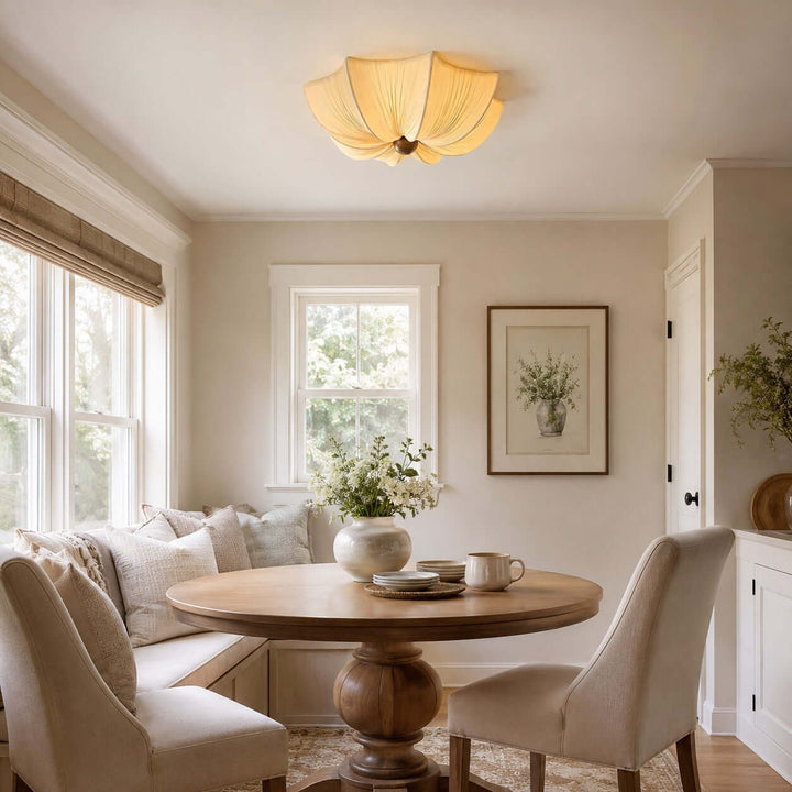 Fabric and wood flush mount ceiling light above a round dining table in a breakfast nook