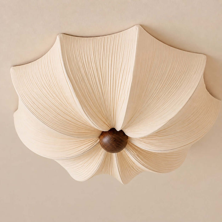 Close-up of the pleated fabric flower shade and rounded walnut wood center