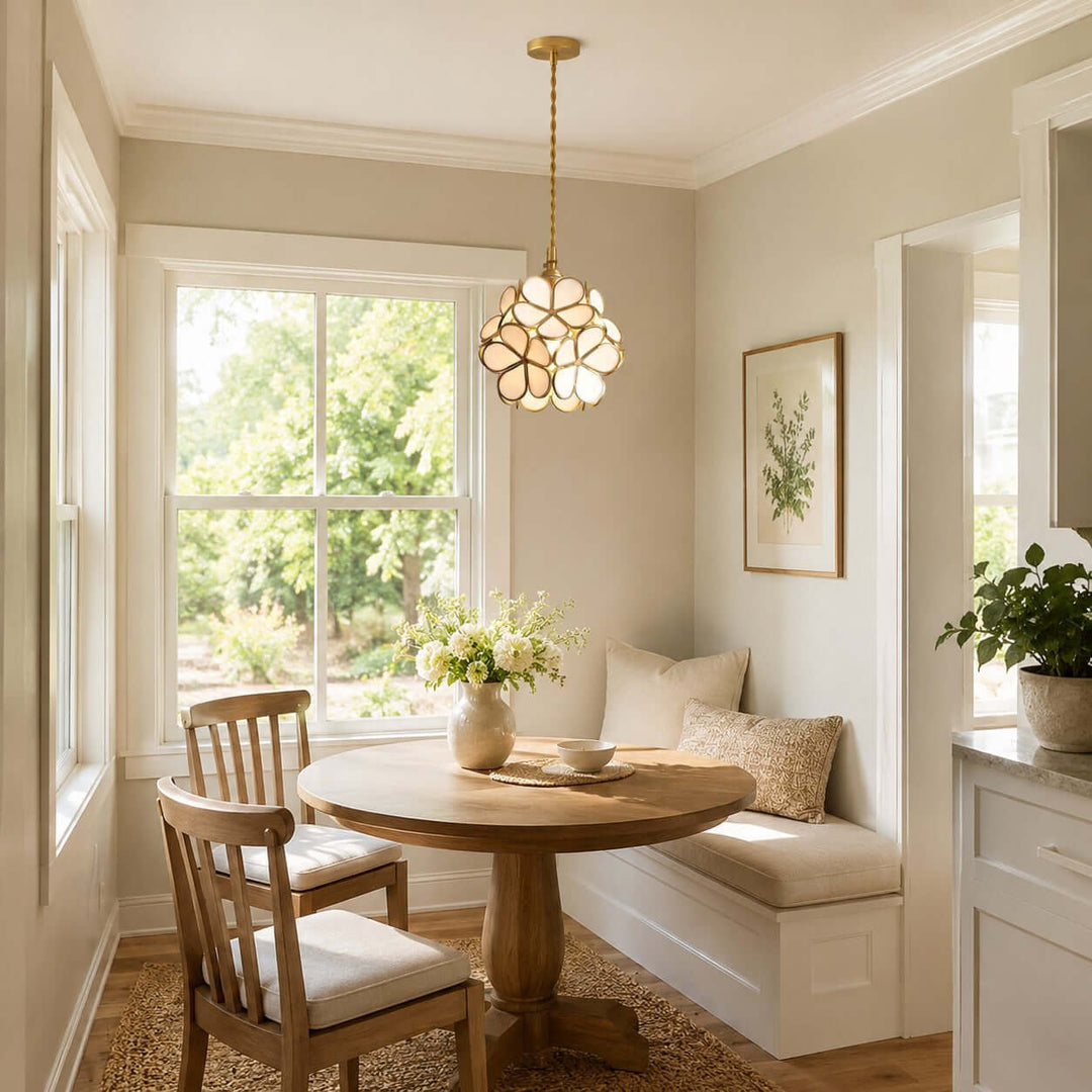White floral glass pendant light above a small round table in a sunlit breakfast nook