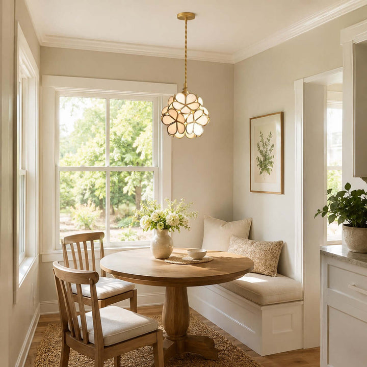 White floral glass pendant light above a small round table in a sunlit breakfast nook