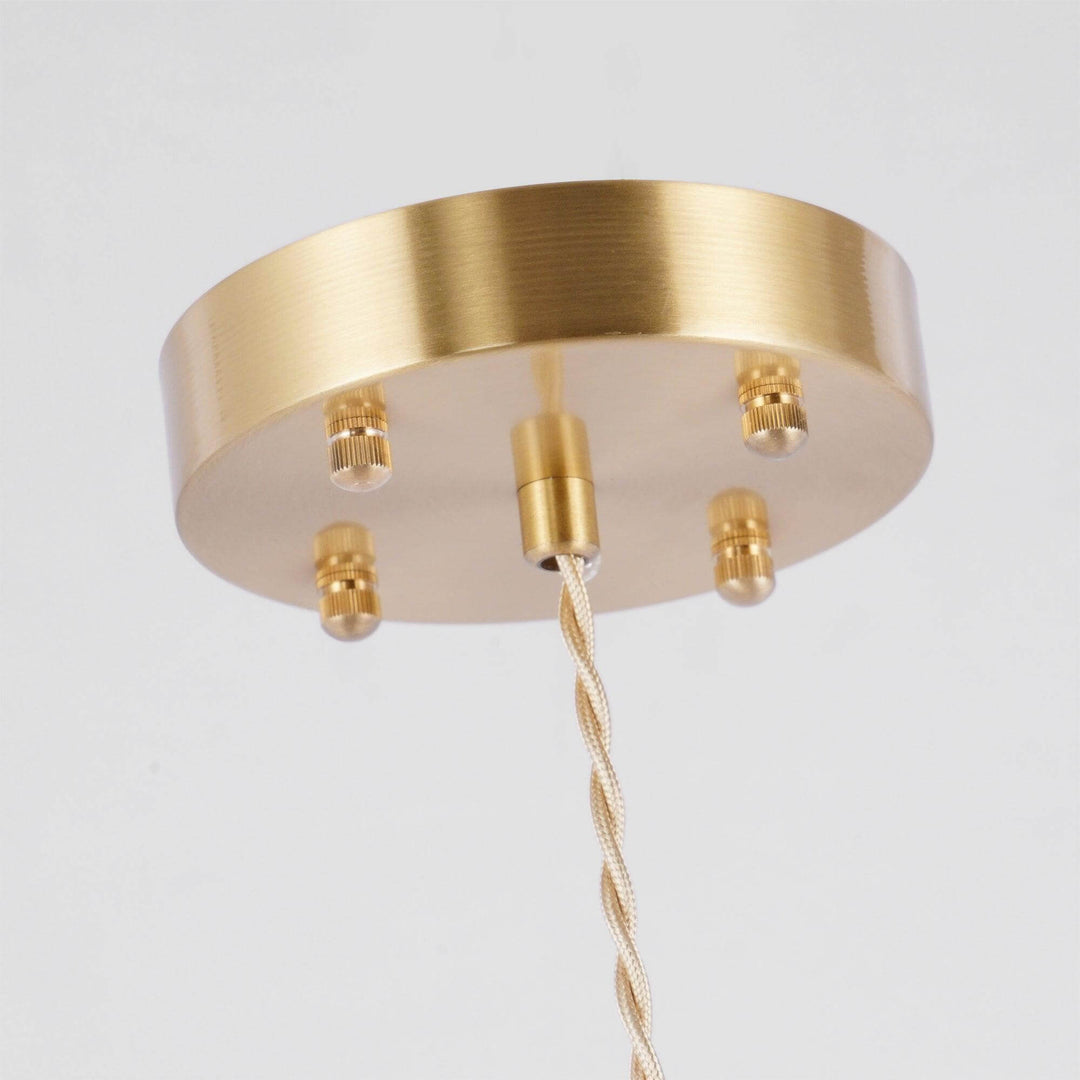 Close-up of the round antique brass ceiling canopy and twisted suspension cord