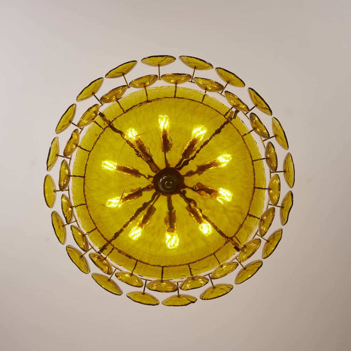 Bottom view of an illuminated green glass chandelier with multiple bulb sockets
