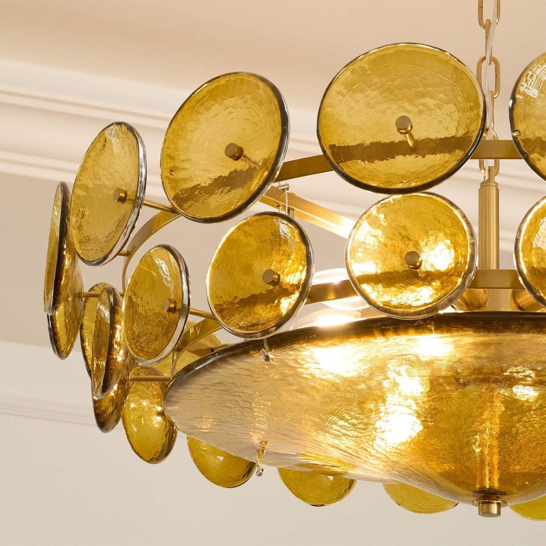 Close-up of green textured glass discs and the gold-tone chandelier frame