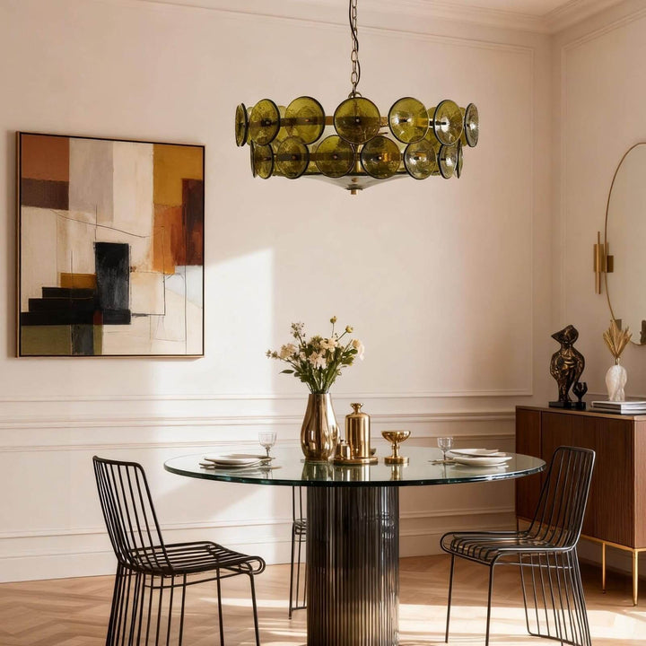 Green glass dining room chandelier hanging above a round glass dining table
