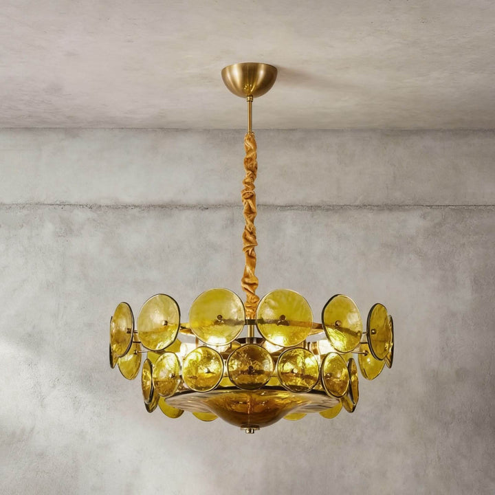 Illuminated green glass disc chandelier with a warm gold-tone metal frame