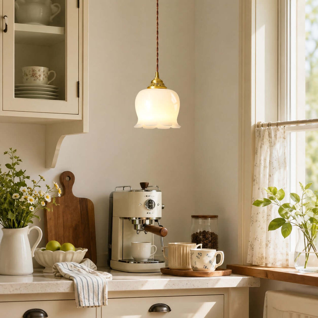 Small brass flower pendant light illuminating a bright kitchen coffee counter with warm ambient light
