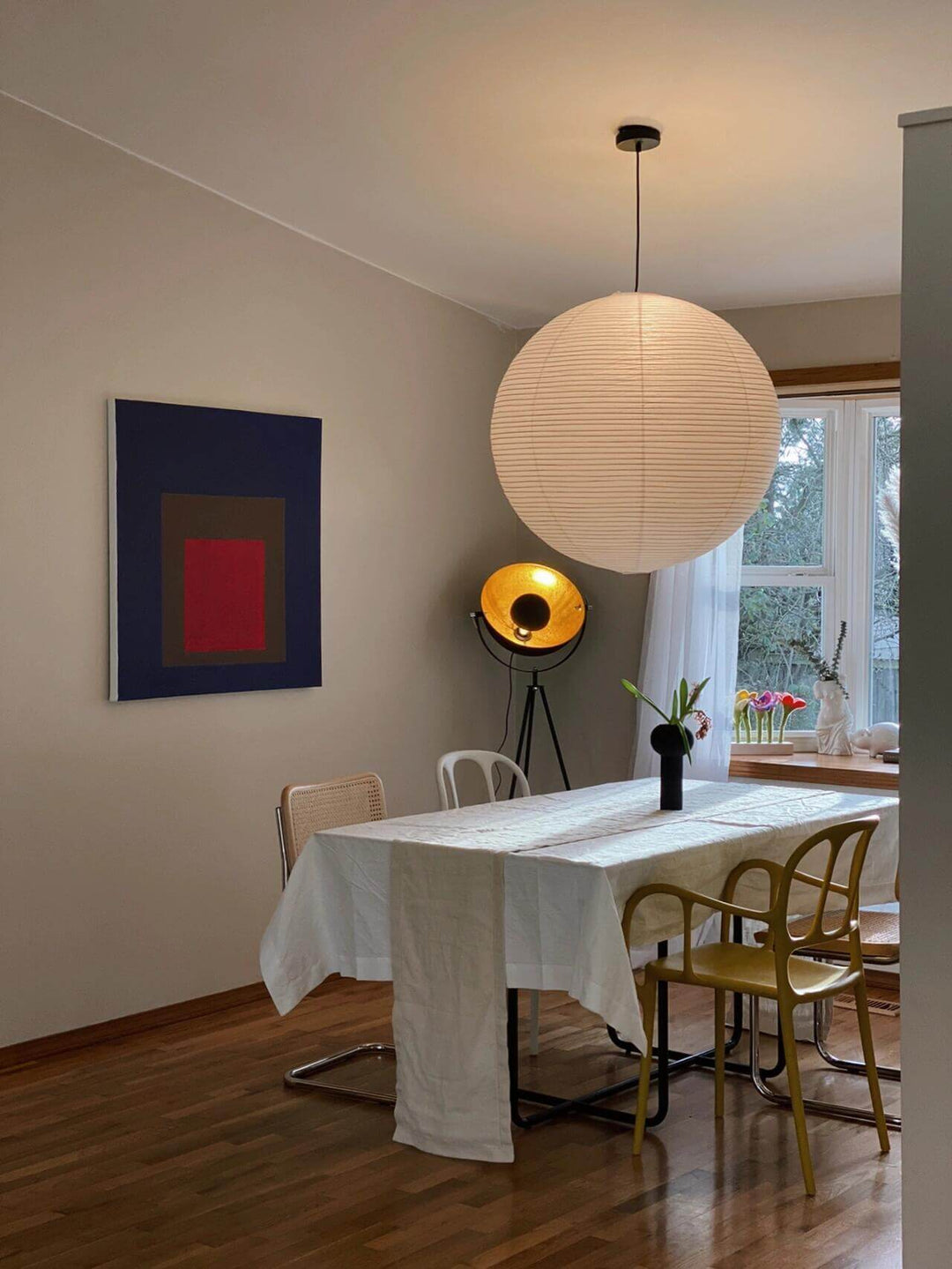 Large round rice paper pendant light illuminating a modern dining room