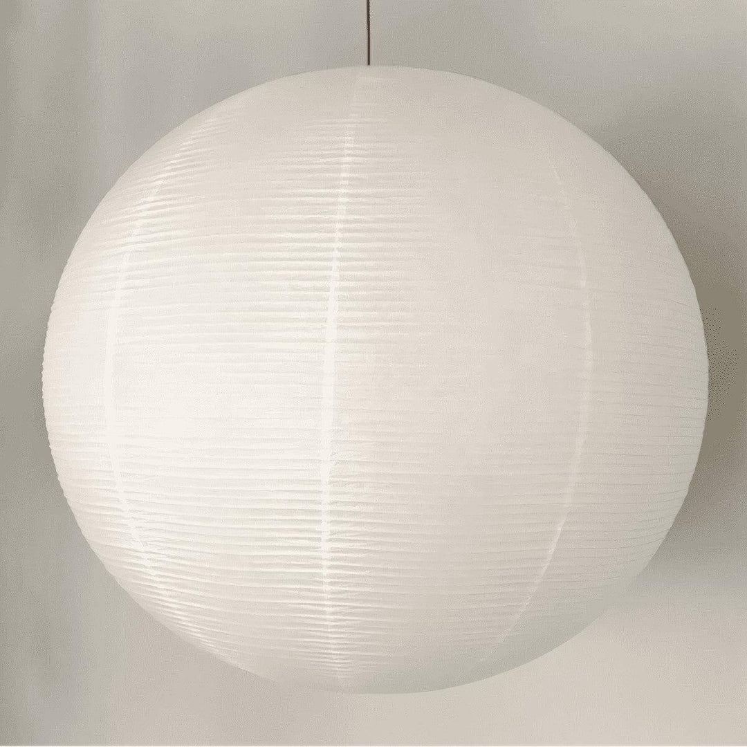 Large white round paper lantern pendant shown close up with a black wire