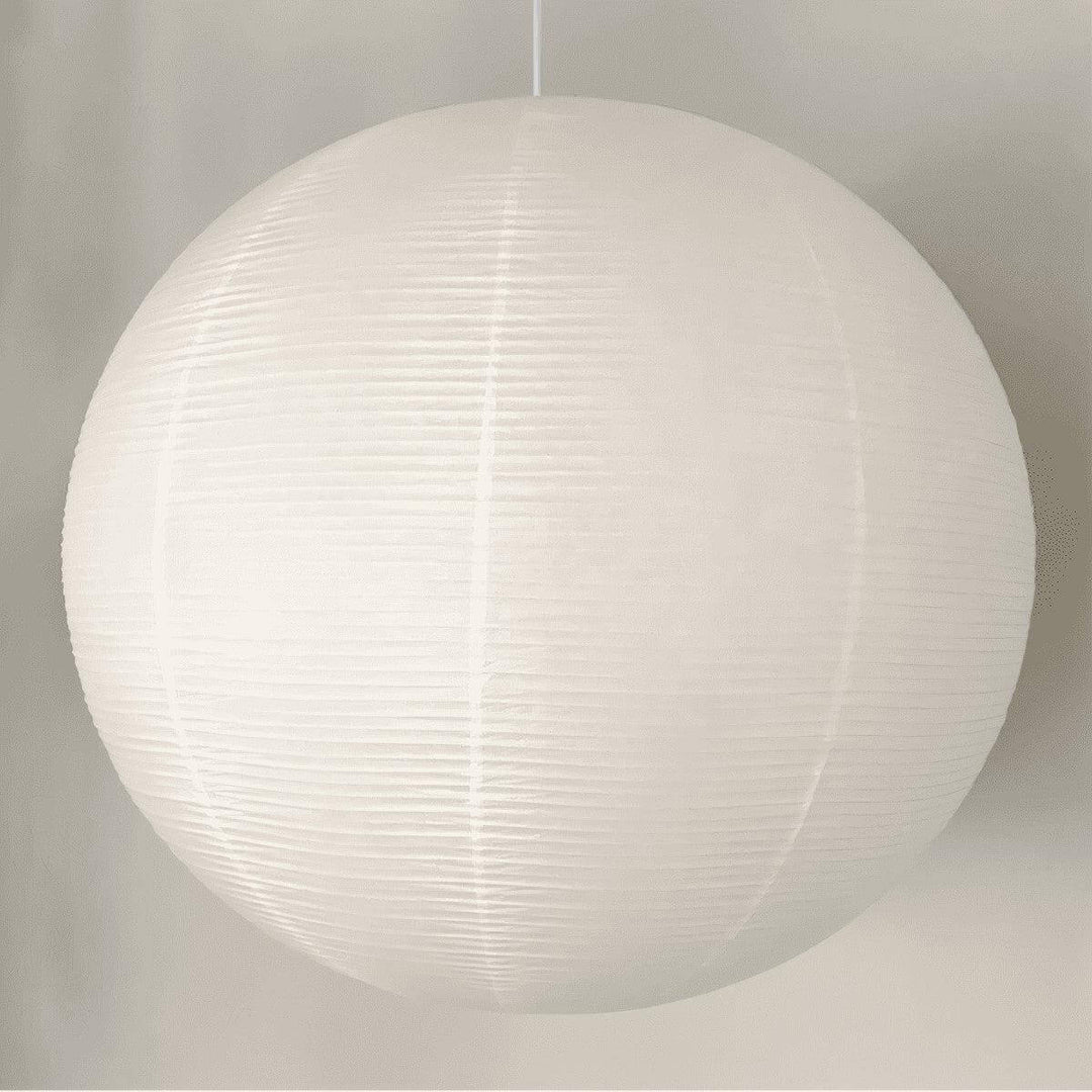 Large white round paper lantern pendant shown close up with a white wire
